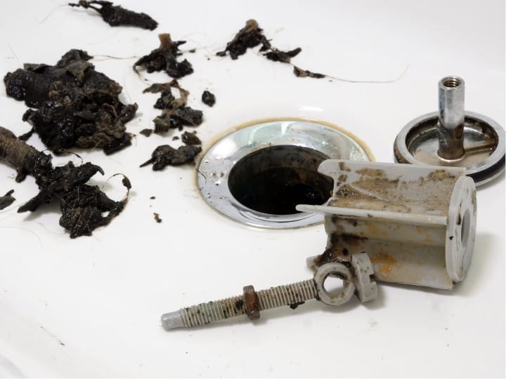 Accumulation de graisse et de cheveux qui bouchent la canalisation