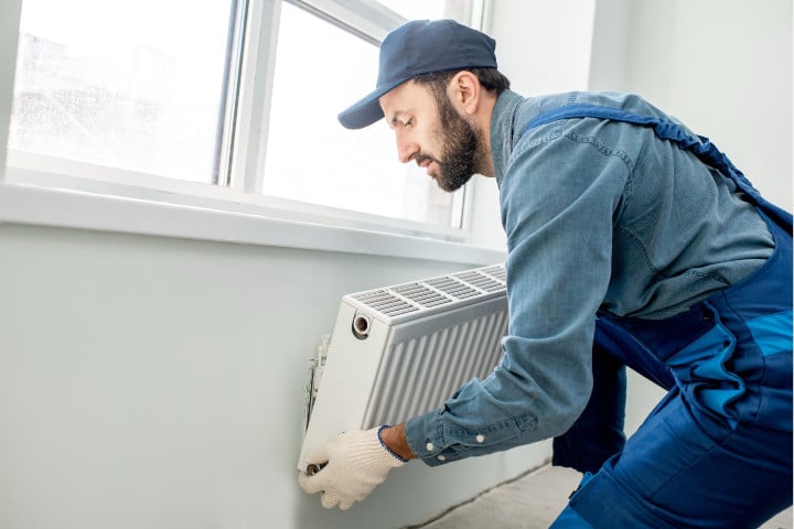 Fixation d'un radiateur électrique contre le mur sous la fenêtre