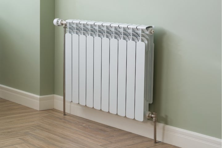 Radiateur adossé à un mur vert dans une maison