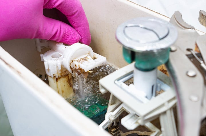 Réparation par un plombier d'une chasse d'eau qui fuit