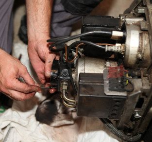 Chauffagiste fait l'entretien d'une chaudière au fioul
